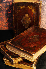 A stack of old leather-bound Jewish books with gold stamping on black background