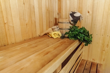 Obraz na płótnie Canvas Interior details Finnish sauna steam room with traditional sauna accessories basin birch broom scoop felt hat towel. Traditional old Russian bathhouse SPA Concept. Relax country village bath concept