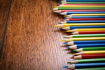 Different colored pencils on the brown wooden table background .Top view .Close up .Color .Pencil.Set