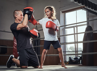 Young boxer trainer is training new girl boxer for special competitions.