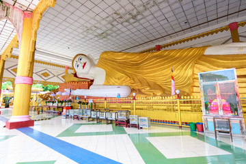 golden statue of reclining buddha at burmese temple