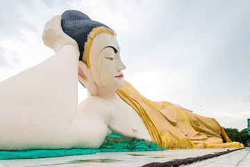 golden statue of reclining buddha at burmese temple