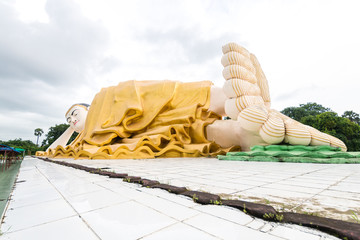 golden statue of reclining buddha at burmese temple