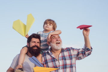 Father and son enjoying outdoor. Dad and son. Father and son playing on blue summer sky. Airplane...