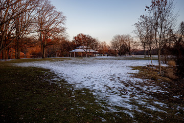 sunset local park with snow covered on the grass