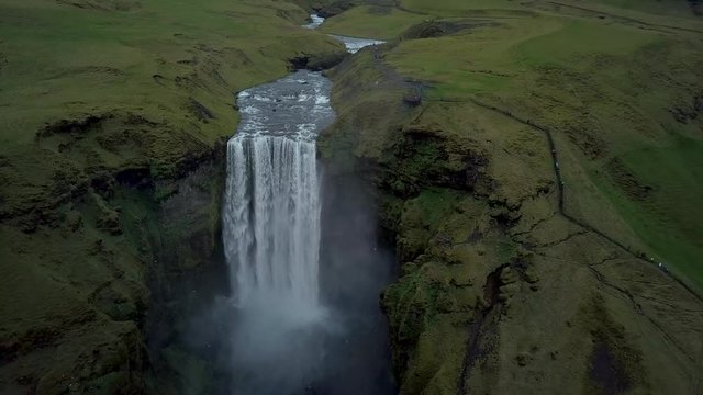 Aerial flight above Skogafoss, famous waterfall in southern Iceland. Most beautiful waterfall in Iceland during  spirng time. Green Iceland.