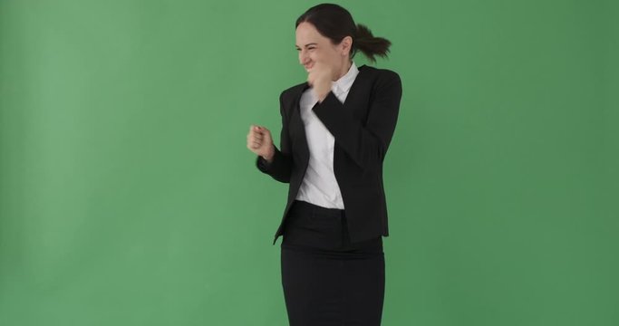 Young businesswoman clapping and jumping in excitement over green background
