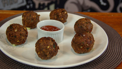 Big fried meatballs served with ketchup sauce