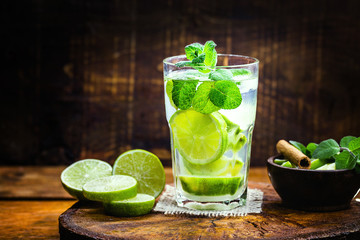 Mojito cocktail at the bar. Mojito cocktail over rustic wood. Cold Mojito, rum, lime and mint tourist drink. Image for menu or restaurant.