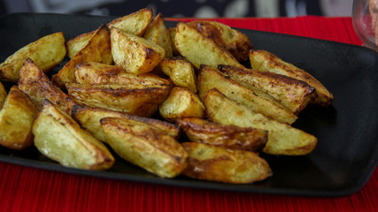 Seasoned rustic fries served on a black tray