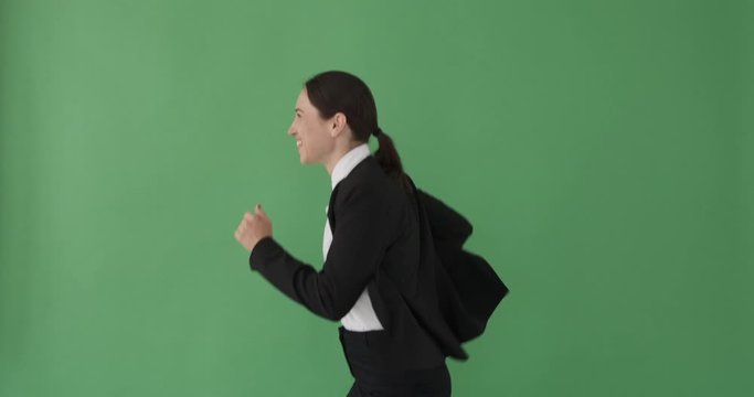 Happy businesswoman running over green background