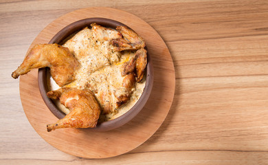 Fried chicken in a plate on a wooden table. Tobacco Chicken. Place for text.
