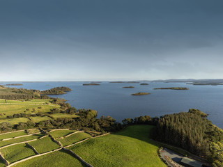 Lake Corrib, county Galway Ireland, Sunny day with clean blue sky and green fields separated by stone fences, islands in the lake, Aerial drone view,
