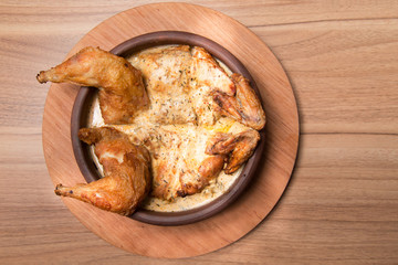 Fried chicken in a plate on a wooden table. Tobacco Chicken. Place for text.
