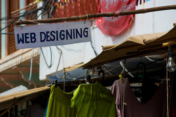 handmade "web designing" sign outside a clothes shop in Pushkar, India