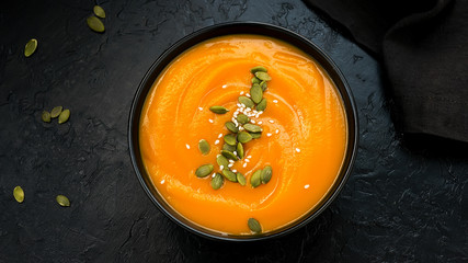 Autumn vegetarian pumpkin cream soup with seeds. Top view