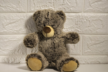  brown teddy bear sitting alone by the wall, goodbye childhood, abandoned toys,