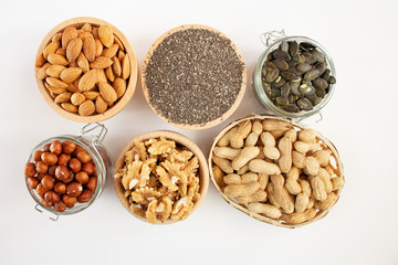 Nuts and seeds in bowls arranged on a white background