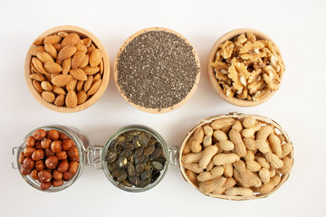 Nuts and seeds in bowls arranged on a white background