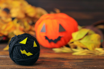 halloween pumpkin made with yarn balls  on wooden background