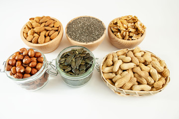 Nuts and seeds in bowls arranged on a white background