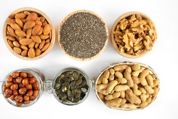 Nuts and seeds in bowls arranged on a white background