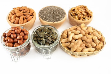 Nuts and seeds in bowls arranged on a white background