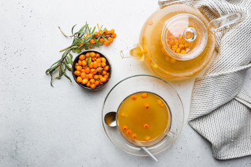 Tea with sea buckthorn on white stone background. top view