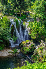 Fototapeta na wymiar Waterfalls of Korana river in Rastoke village, near Slunj, Croatia, beautiful landscape with green trees on sunny summer day