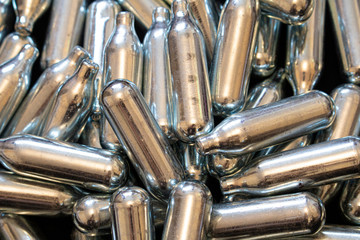 Nitrous Oxide Metal Bulb Canisters Recreational Drugs on Black Background