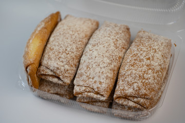 Tasty pastries in plastic packaging on a white background
