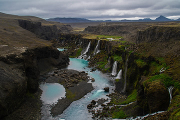 Fototapeta na wymiar Scenic landscape view of incredible Sigoldugljufur canyon in highlands with turquoise river, Iceland. Volcanic landscape on background. Popular tourist attraction.