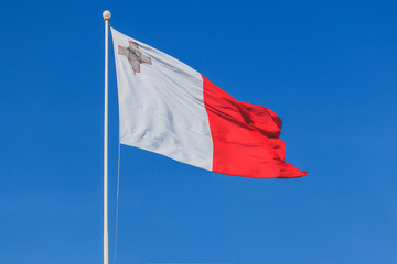 Fototapeta na wymiar Malta national flag is waving in deep blue sky background