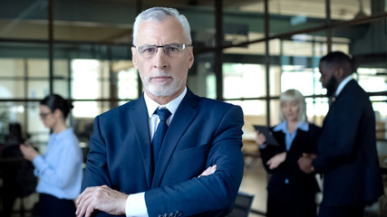 Self-confident aged man in suit looking camera, business leader, company career