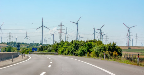 Fototapeta premium Wind turbines with power line in the sunset 