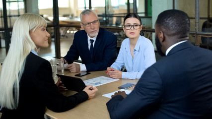 Office workers negotiating in meeting room, business offer, partnership deal
