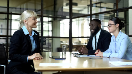Blond business woman smiling at partners, meeting in office, successful career