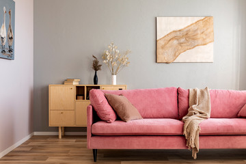 Living room in neutral colors with accents of pink and wood