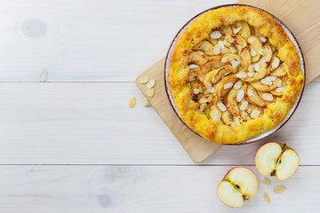 Apple galette with cinnamon and almonds on a wooden table. Homemade pie.