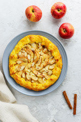Cottage cheese galette with apples, cinnamon and almonds on a gray background.