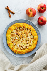 Cottage cheese galette with apples, cinnamon and almonds on a gray background.