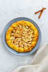 Cottage cheese galette with apples, cinnamon and almonds on a gray background.
