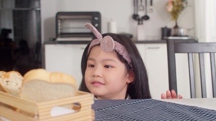Asian Japanese girl eat bread at home. Asian women feeling happy pick sandwich which put it on the table on table in the kitchen in the morning. Slow motion shot. - Powered by Adobe