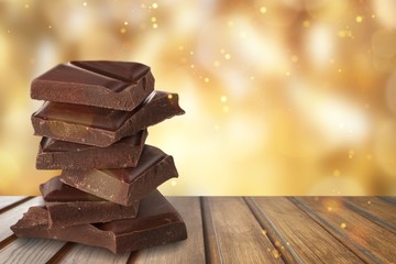 Dark chocolate on wooden table with sun lights