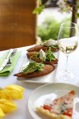 Appetizing bruschetta with minced fish and herbs. Restaurant table setting.
