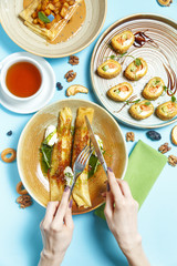 Pancakes, a traditional dish of Russian national cuisine on a blue background. Traditional treat for the holiday Maslenitsa. Top view. Restaurant table setting