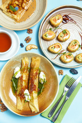 Pancakes, a traditional dish of Russian national cuisine on a blue background. Traditional treat for the holiday Maslenitsa. Top view. Restaurant table setting