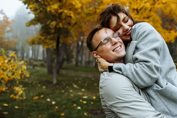 Fototapeta premium Loving couple in stylish casual wear hugs in the park in the autumn season. Autumn. Golden autumn. Golden leaves..