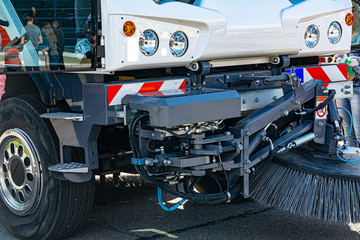 Industrial sweeper, road cleaner with brushes. Brushing the road. The concept of community road...