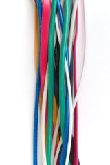 Multicolored tangled cables across a white background. Network infrastructure, tech support abstract concept.